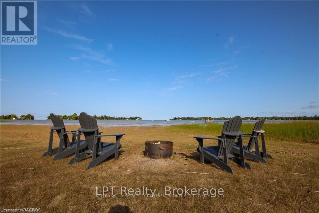 Chairs and a fire pit on the private beach at 21 Tyson Lane, looking across Howdenvale Bay