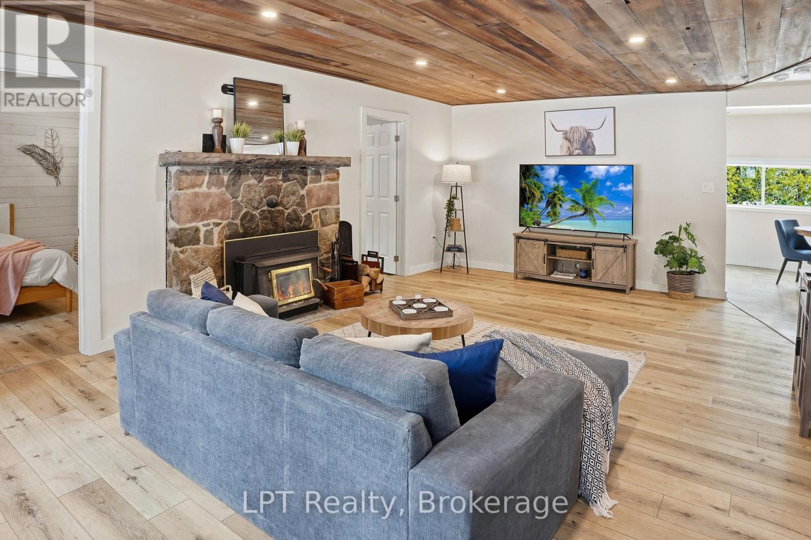 Living room with a wood-burning fireplace set in natural stone
